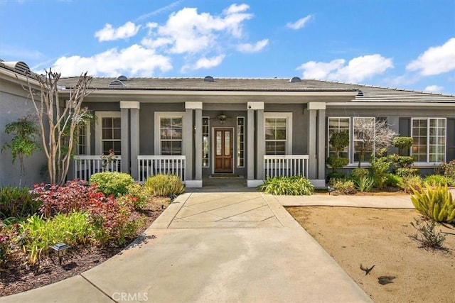 view of exterior entry featuring covered porch