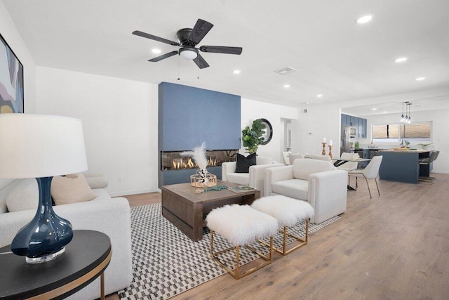 living room with ceiling fan and light hardwood / wood-style floors