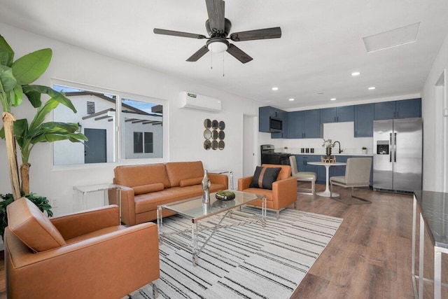 living room featuring hardwood / wood-style flooring, a wall unit AC, ceiling fan, and sink