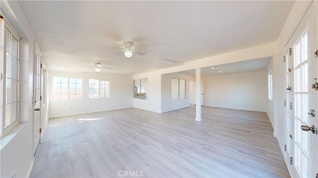 spare room with ceiling fan, light hardwood / wood-style floors, and a textured ceiling