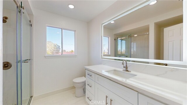 bathroom featuring tile patterned floors, vanity, toilet, and a shower with door