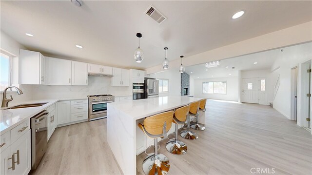 kitchen with white cabinets, stainless steel appliances, a healthy amount of sunlight, and sink