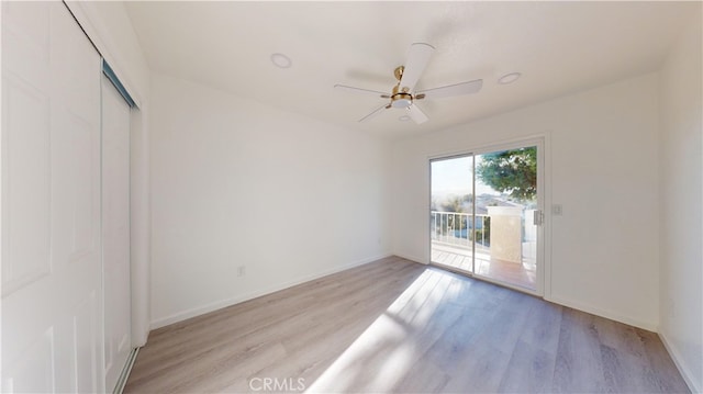 empty room with ceiling fan and light hardwood / wood-style flooring