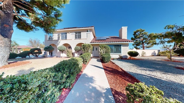 mediterranean / spanish home featuring solar panels and a balcony