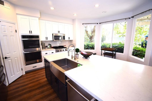 kitchen featuring dark hardwood / wood-style floors, sink, white cabinetry, and stainless steel appliances