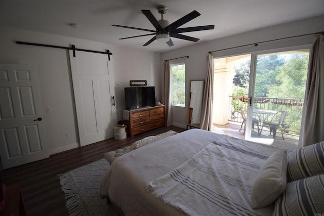 bedroom featuring a barn door, ceiling fan, multiple windows, and access to exterior