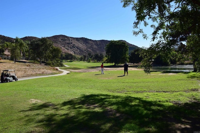 surrounding community with a lawn and a mountain view