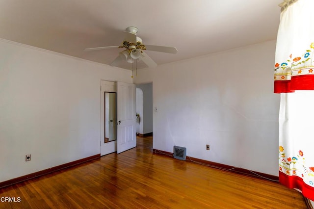 empty room featuring wood-type flooring, ceiling fan, and crown molding