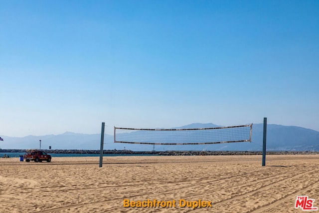 surrounding community with volleyball court and a water and mountain view