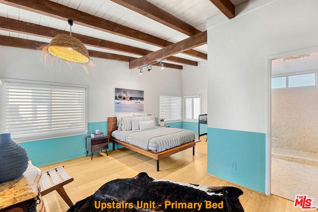 bedroom featuring beamed ceiling and hardwood / wood-style flooring