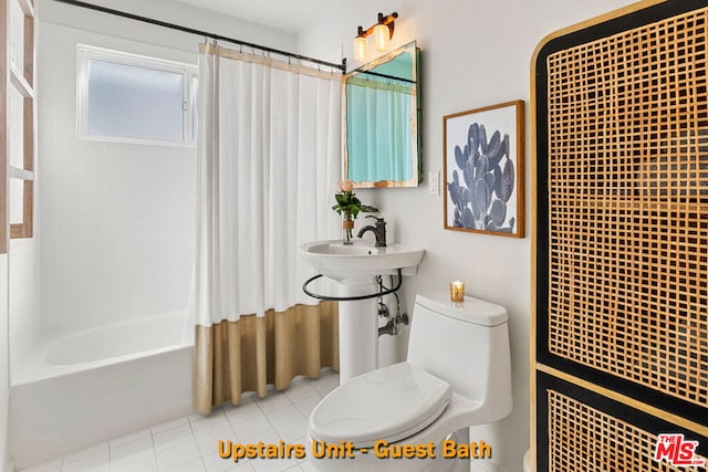 bathroom with tile patterned floors, shower / bath combination with curtain, and toilet