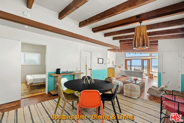 dining space featuring beam ceiling and light wood-type flooring