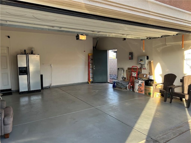 garage featuring stainless steel fridge with ice dispenser and a garage door opener