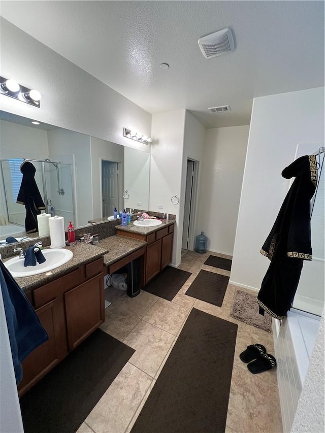 bathroom with tile patterned floors, vanity, independent shower and bath, and a textured ceiling