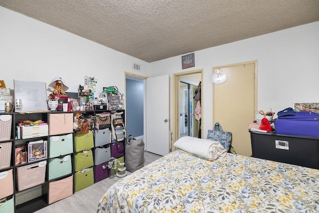 bedroom with wood-type flooring and a textured ceiling