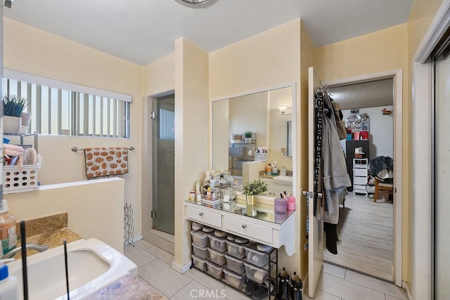 bathroom with tile patterned flooring, vanity, and a shower with shower door