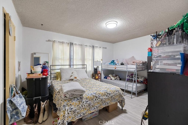 bedroom featuring a textured ceiling and hardwood / wood-style flooring