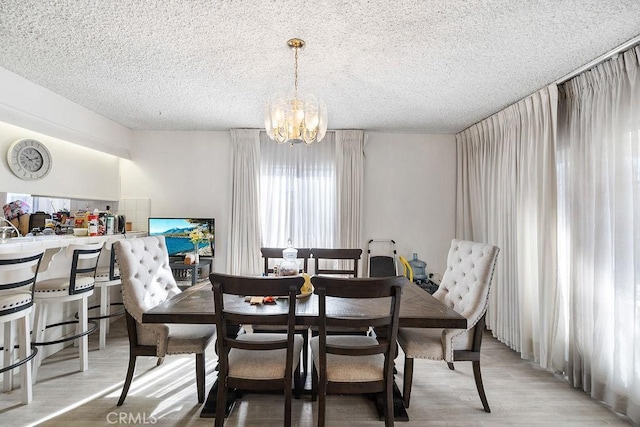 dining room featuring a chandelier, a textured ceiling, and hardwood / wood-style flooring