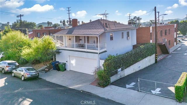 view of front of property featuring a balcony and a garage