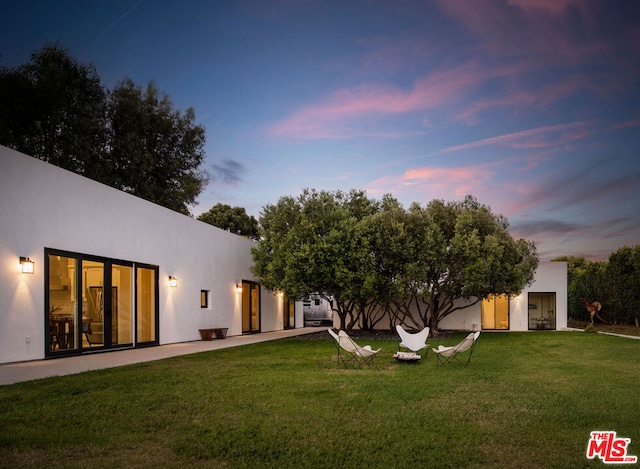 back house at dusk with a yard