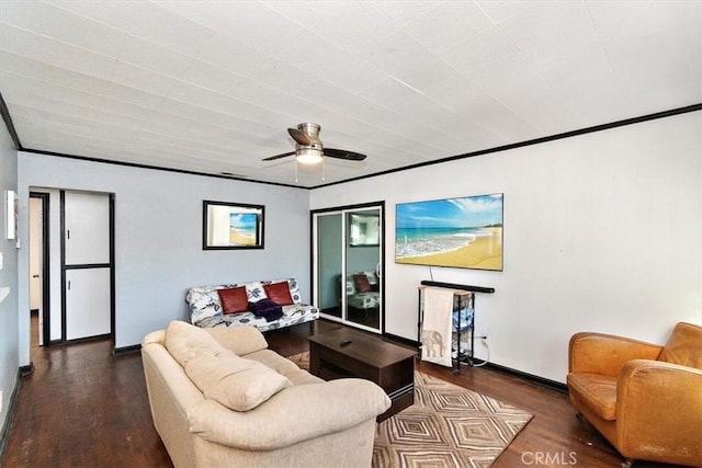 living room featuring ceiling fan, ornamental molding, and dark wood-type flooring