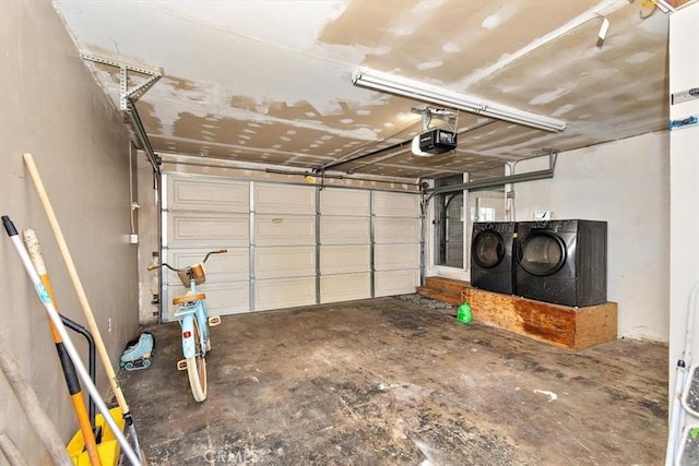 garage with separate washer and dryer and a garage door opener