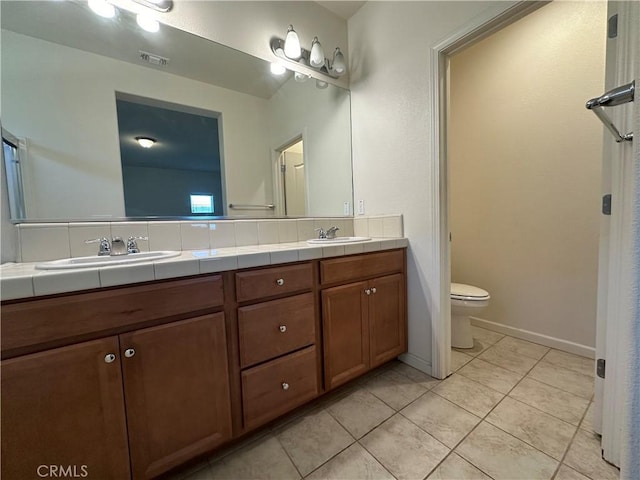 bathroom with tile patterned flooring, vanity, and toilet