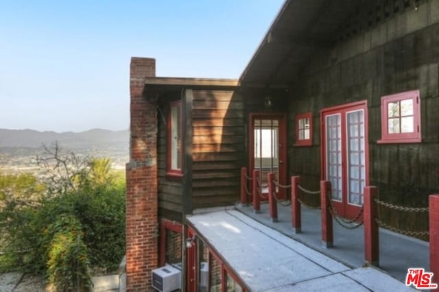 view of property exterior with a mountain view and french doors