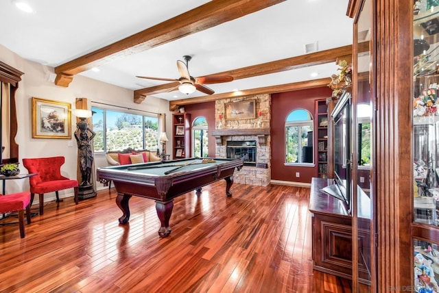 game room with beam ceiling, ceiling fan, hardwood / wood-style floors, a fireplace, and pool table