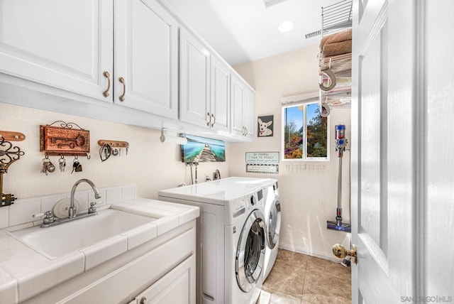 laundry room with separate washer and dryer, sink, light tile patterned floors, and cabinets