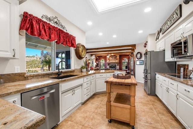 kitchen with kitchen peninsula, sink, white cabinetry, and stainless steel appliances