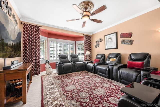 cinema room featuring ceiling fan, light colored carpet, and crown molding