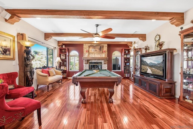 rec room featuring hardwood / wood-style floors, a stone fireplace, beamed ceiling, and billiards