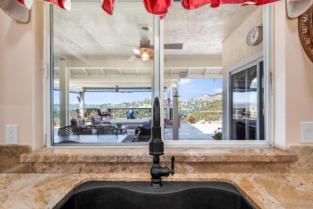 kitchen featuring a mountain view, a textured ceiling, plenty of natural light, and sink