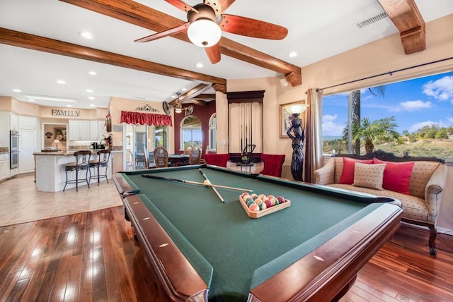 rec room featuring beamed ceiling, a healthy amount of sunlight, and hardwood / wood-style flooring