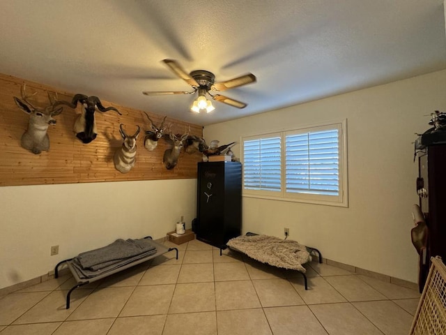 unfurnished bedroom featuring ceiling fan, light tile patterned flooring, and a textured ceiling