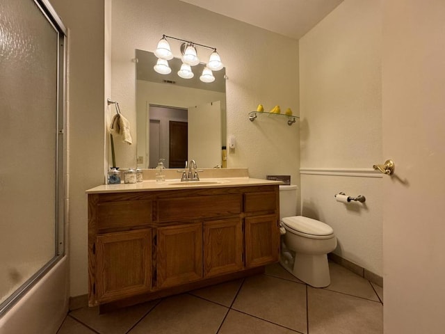 full bathroom with tile patterned flooring, vanity, enclosed tub / shower combo, and toilet