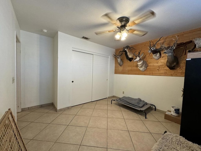 interior space featuring ceiling fan, a closet, and light tile patterned floors