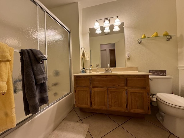 full bathroom featuring tile patterned floors, vanity, toilet, and shower / bath combination with glass door