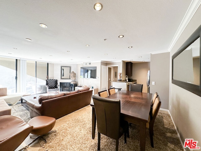 dining room with a textured ceiling and crown molding