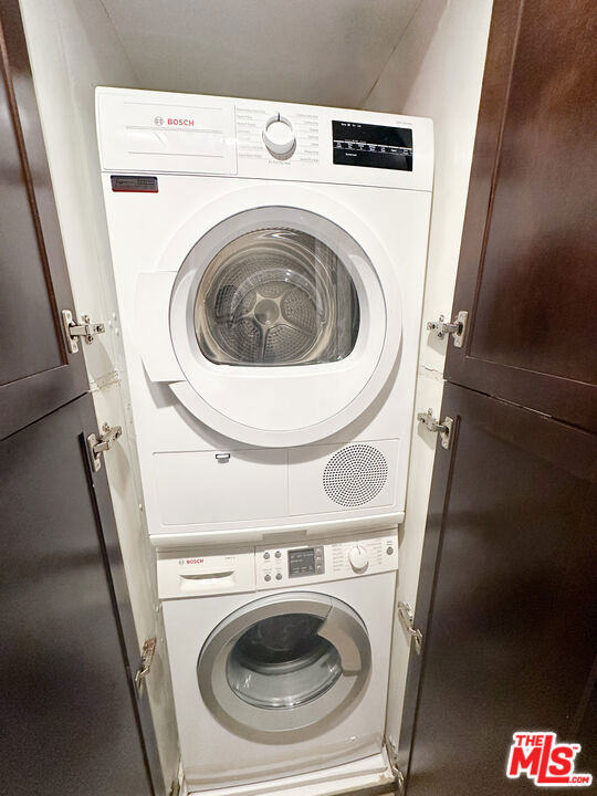 laundry area featuring stacked washer and clothes dryer