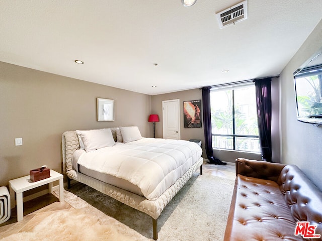 bedroom with light carpet and multiple windows