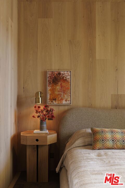 bedroom featuring wood walls