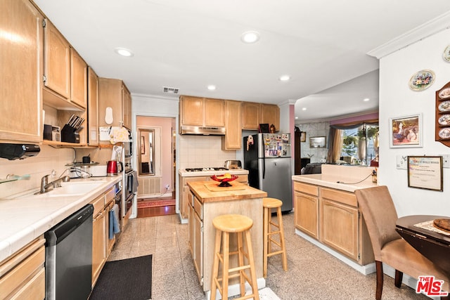 kitchen featuring wood counters, a breakfast bar, sink, ornamental molding, and appliances with stainless steel finishes