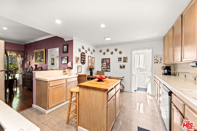 kitchen featuring wood counters, light hardwood / wood-style flooring, ornamental molding, kitchen peninsula, and a breakfast bar area