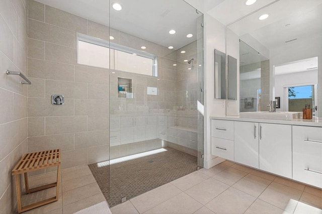 bathroom featuring tile patterned flooring, vanity, and tiled shower