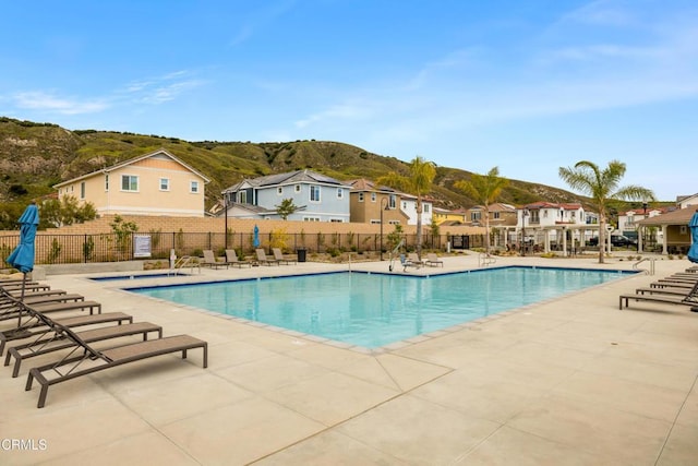 view of swimming pool with a mountain view and a patio area