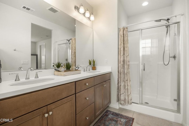 bathroom with tile patterned floors, vanity, and tiled shower