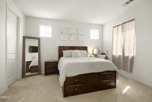 bedroom featuring light colored carpet and multiple windows