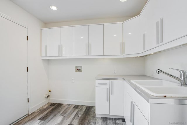 washroom with sink, hookup for a washing machine, cabinets, and dark hardwood / wood-style floors